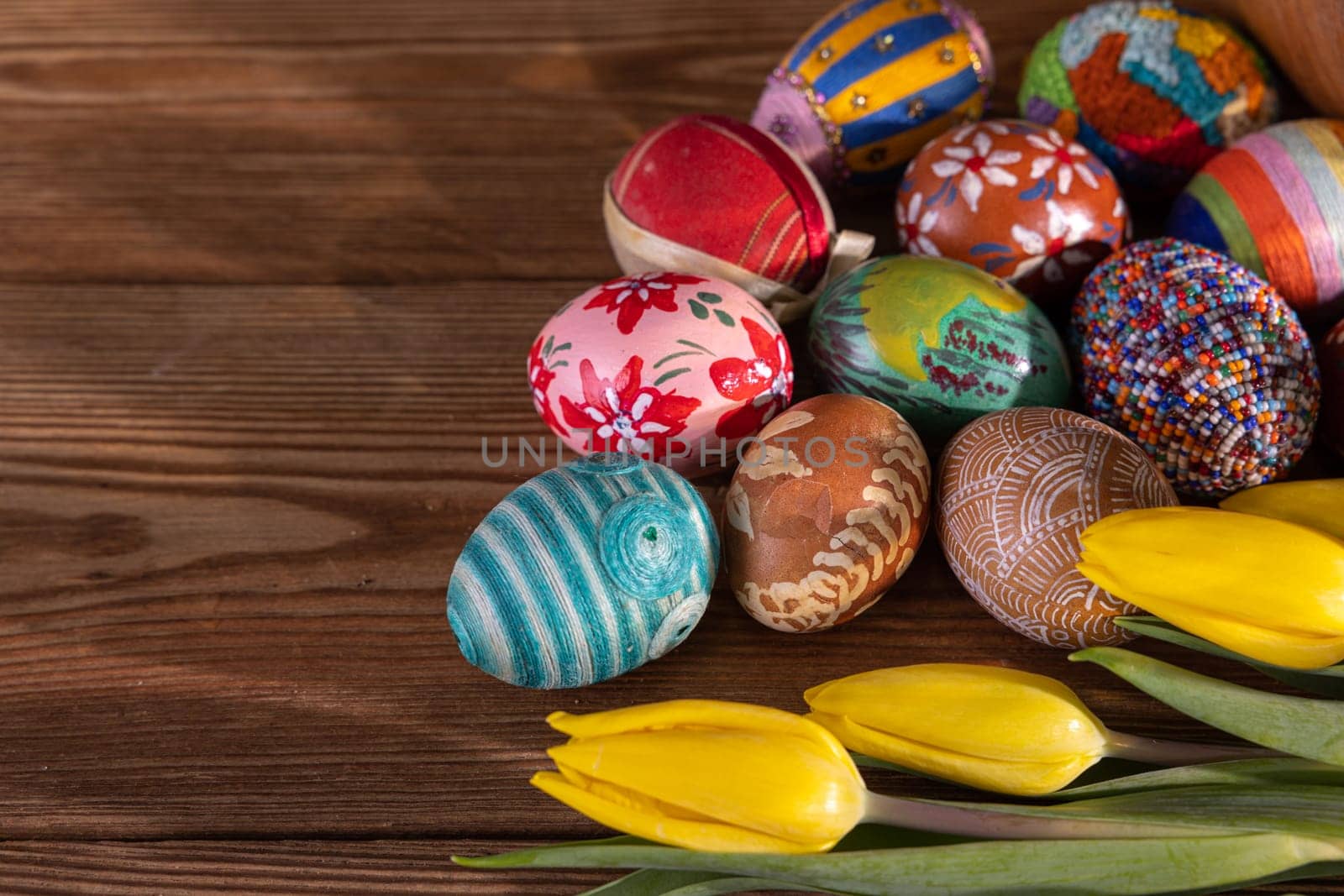 Many Easter eggs in different patterns and colors form a composition for Easter. The entire Christmas decoration seen from above.