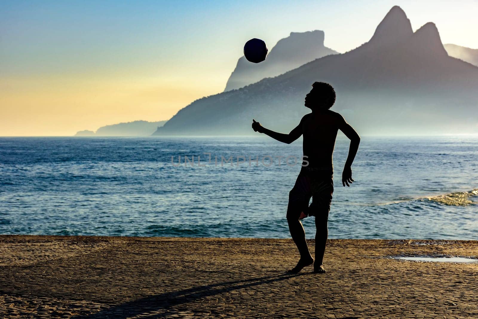 Boy playing soccer in front of the sea by Fred_Pinheiro