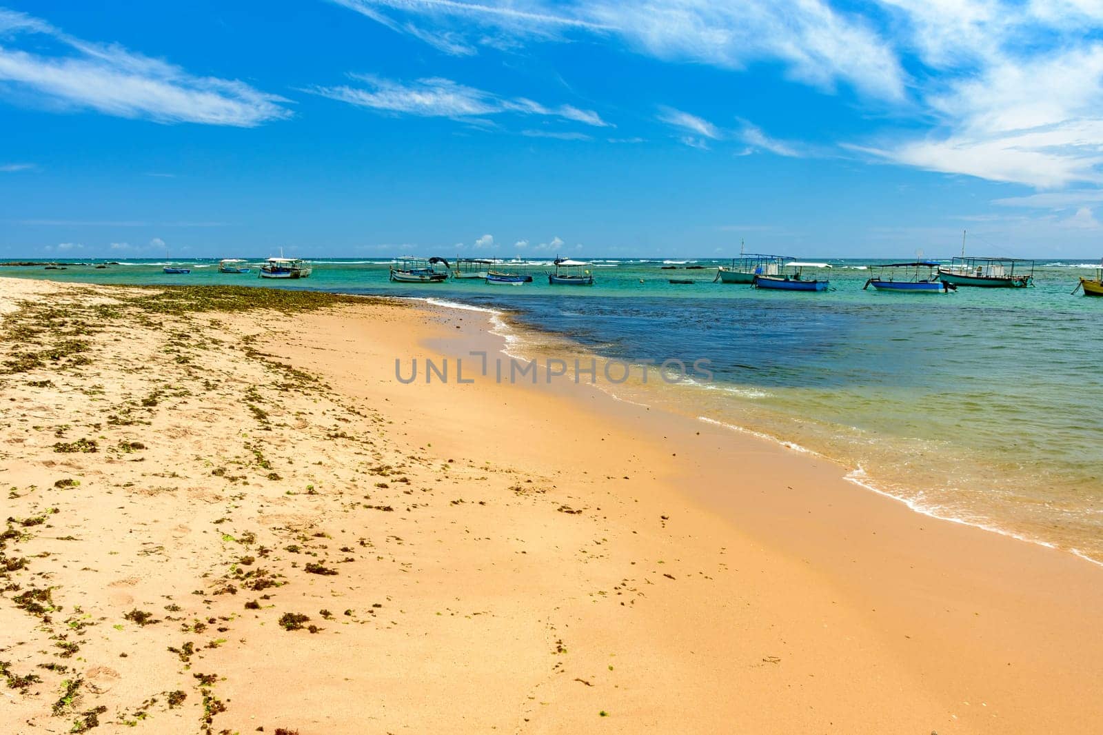Boats on the transparent waters of Itapua beach in the city of Salvador in Bahia on a sunny day