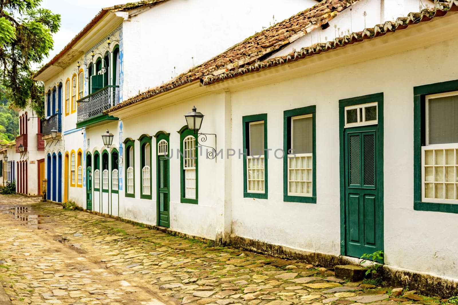 Street with cobblestone pavement and historic colonial-style houses by Fred_Pinheiro