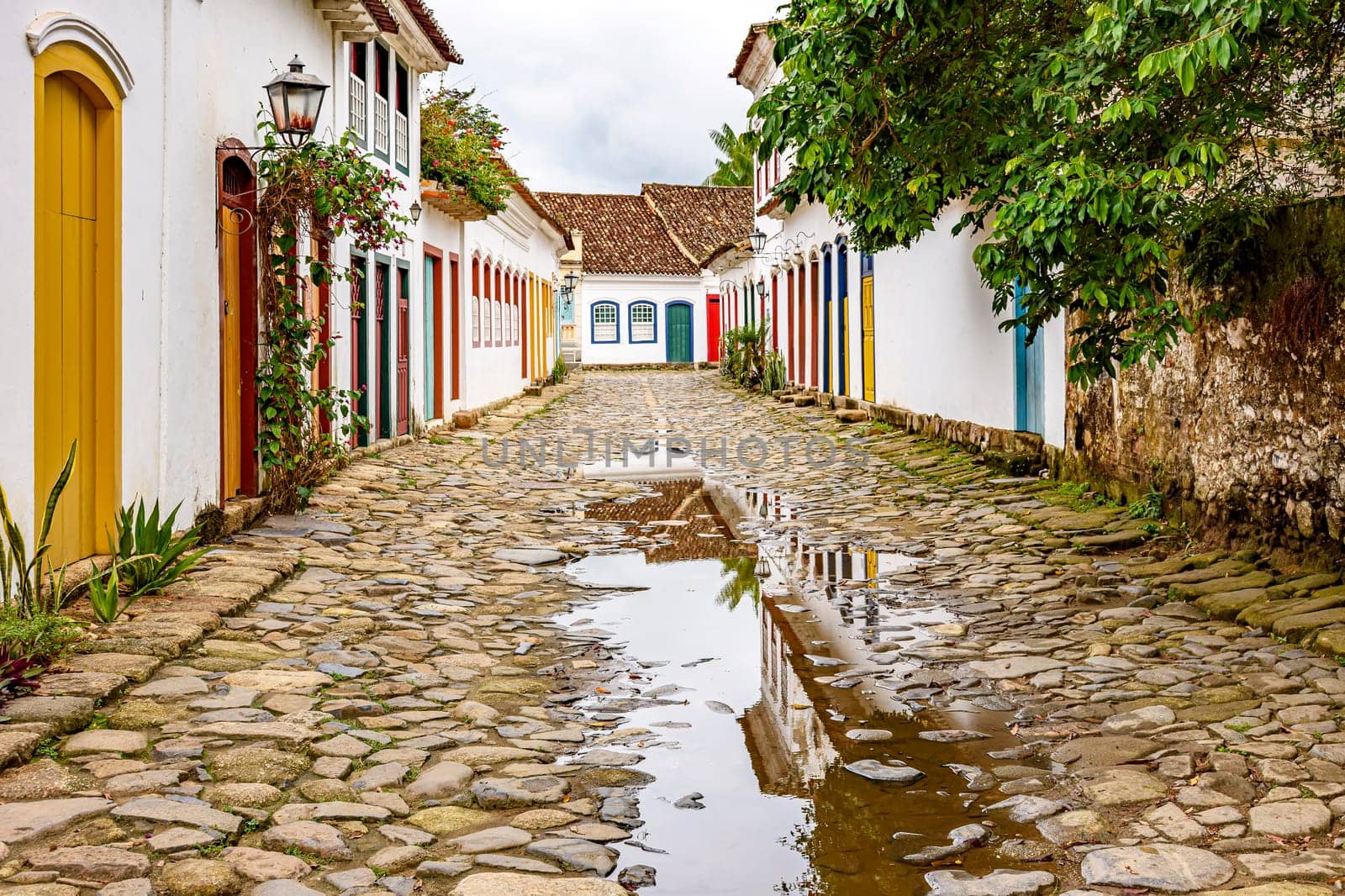Cobblestone street with colorful colonial houses and reflections in the puddles in the historic city of Paraty, Rio de Janeiro, Brazil