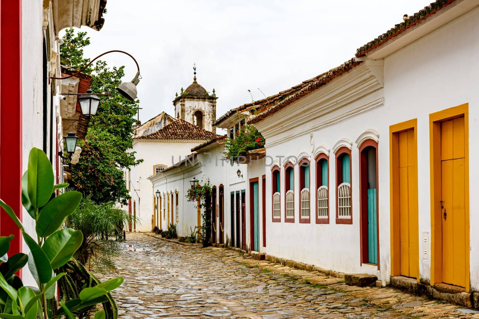 Cobblestone street in the historic center of Paraty with old church in the background