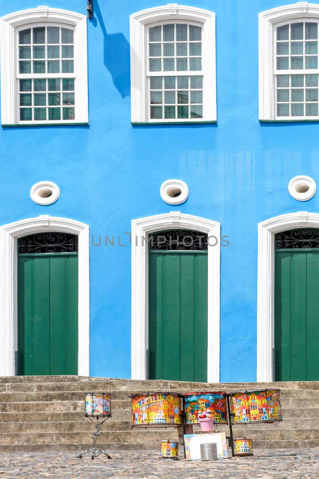 Colorful drums in front of colonial style facade and stairs on the slopes of Pelourinho in Salvador, Bahia