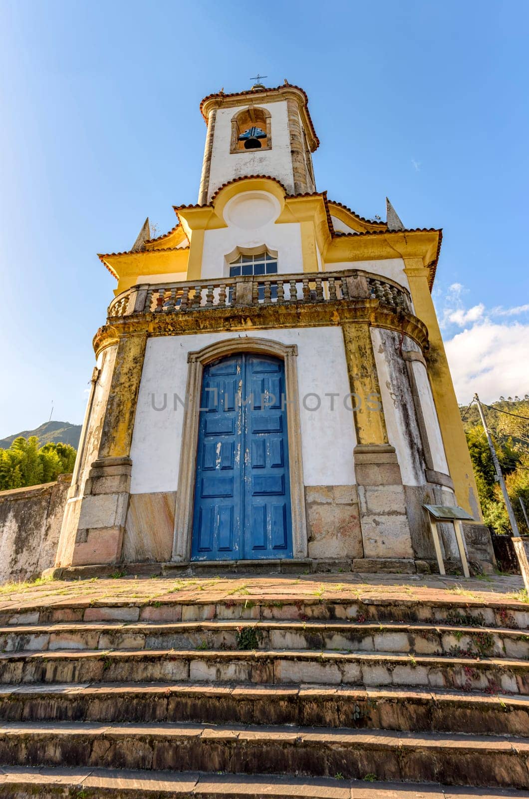 Historic church with its stairs, bell and tower in the city of Ouro Preto in Minas Gerais seen from below