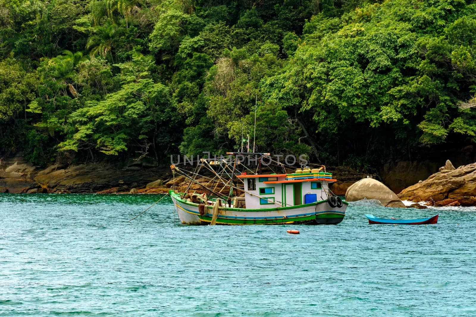 Fishing trawler anchored along the rocks and forest by Fred_Pinheiro