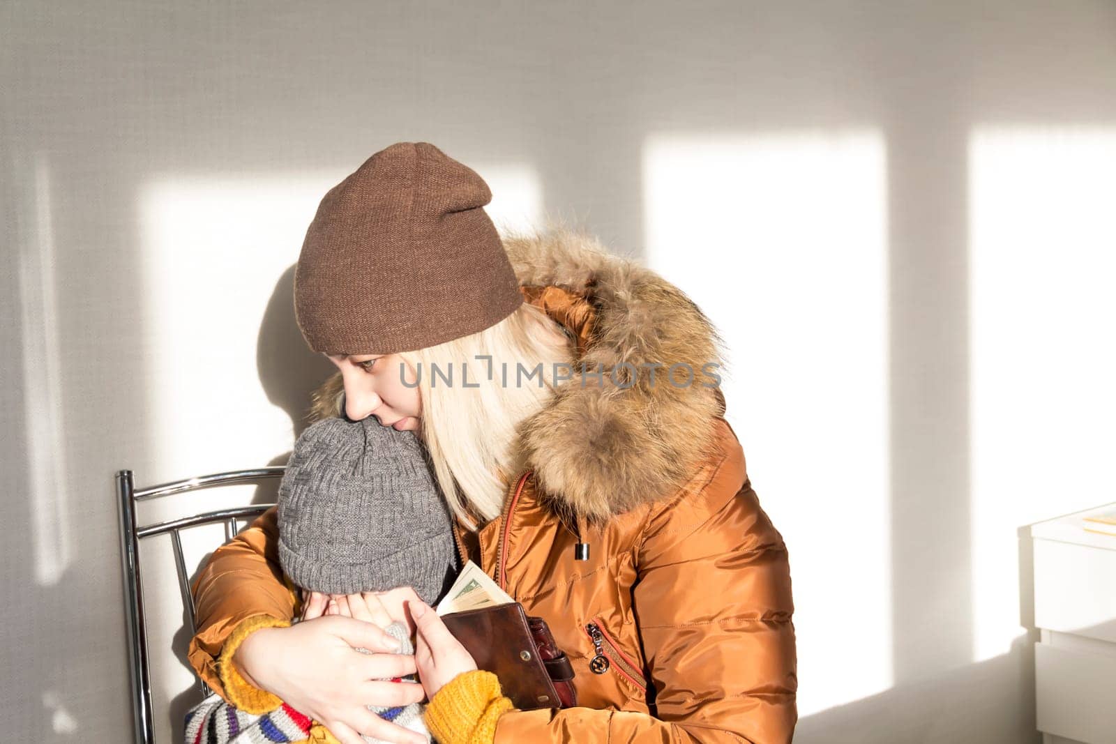 A small child is crying in her mother's arms from problems and stress. The concept of the economic crisis and large utility bills in homes. by Alla_Yurtayeva