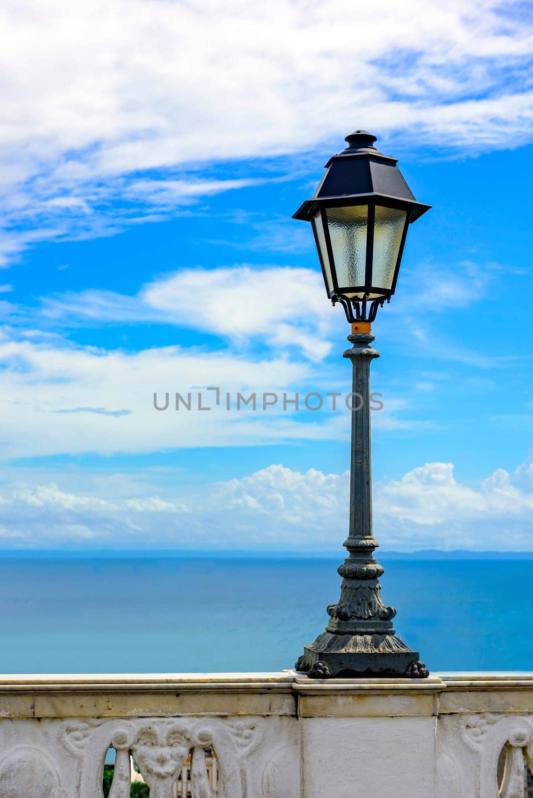 Urban Lampposts on ancient wall with the sea in the background in the city of Salvador, Bahia