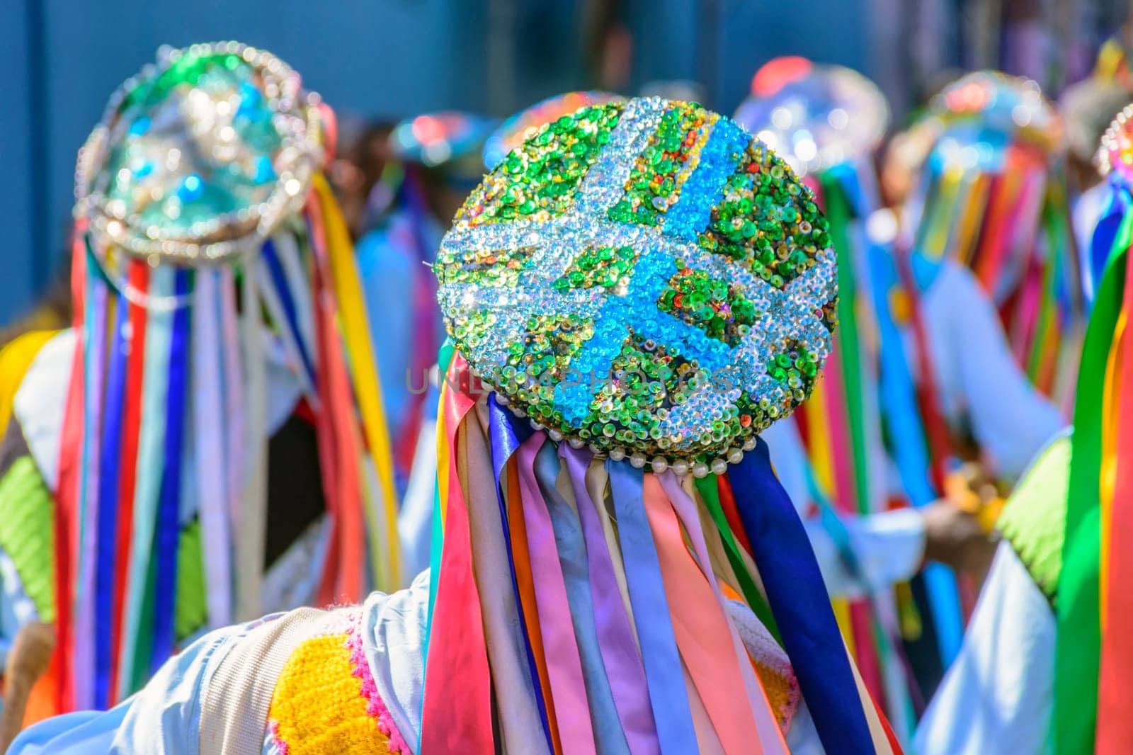 Men dressed in colorful clothes and hats attending a popular religious festival in Minas Gerais, Brazil