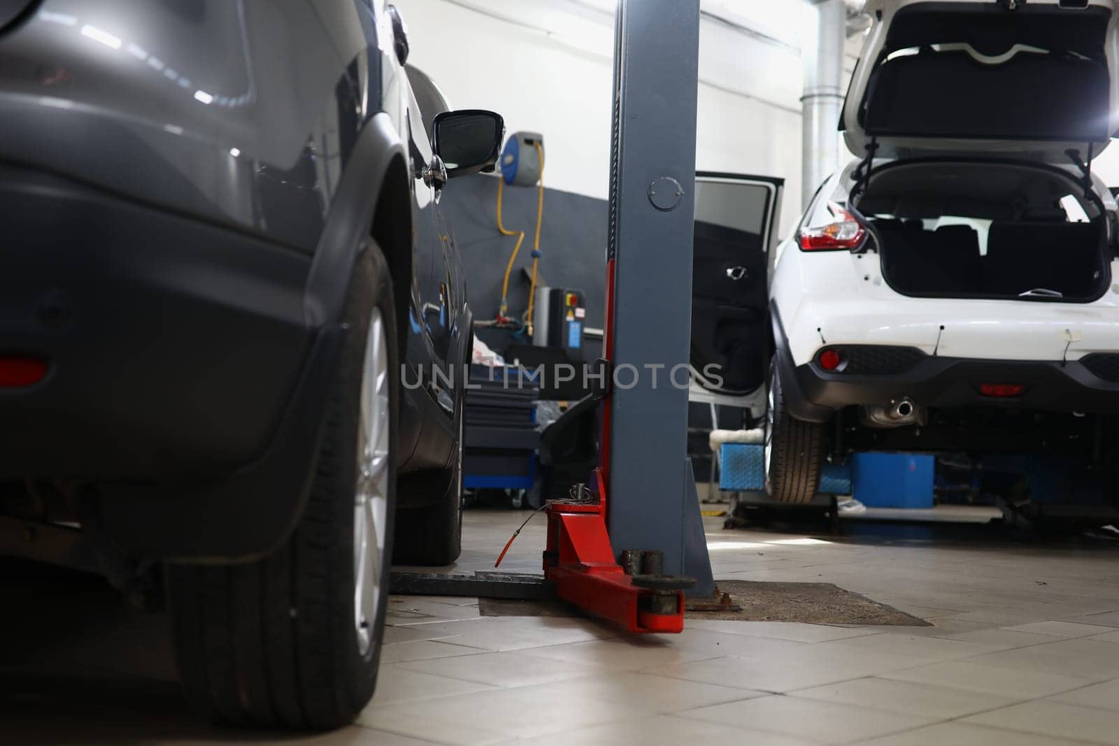 Car repair station with cars and lifts. Garage work and auto repair concept
