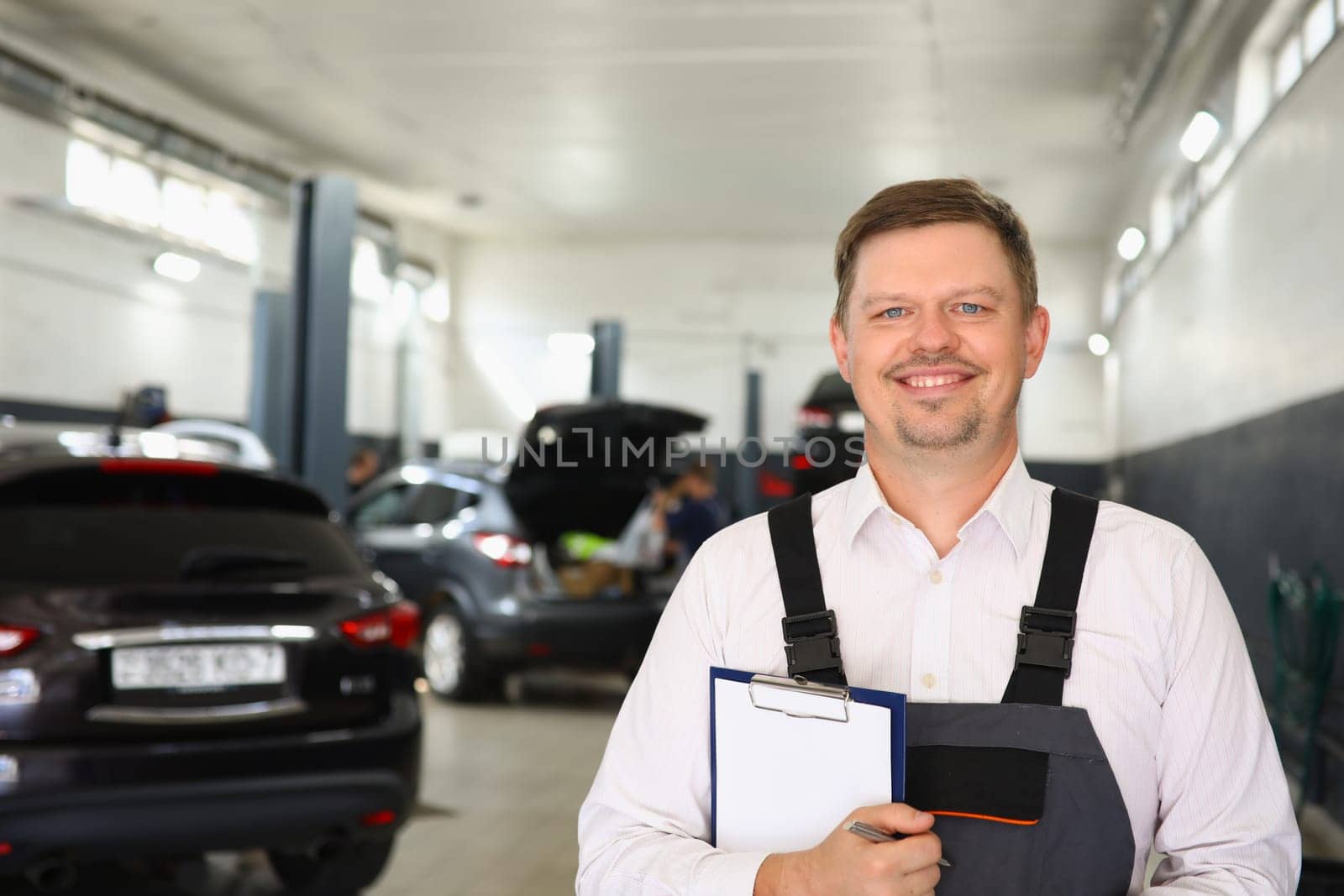 Portrait of confident male mechanic in workshop. Car service and repair concept
