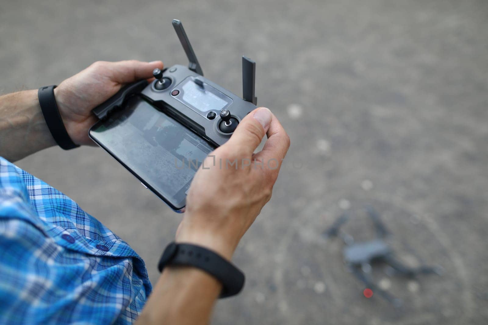 Man holds remote control in hands and controls drone. New technologies and innovation concept