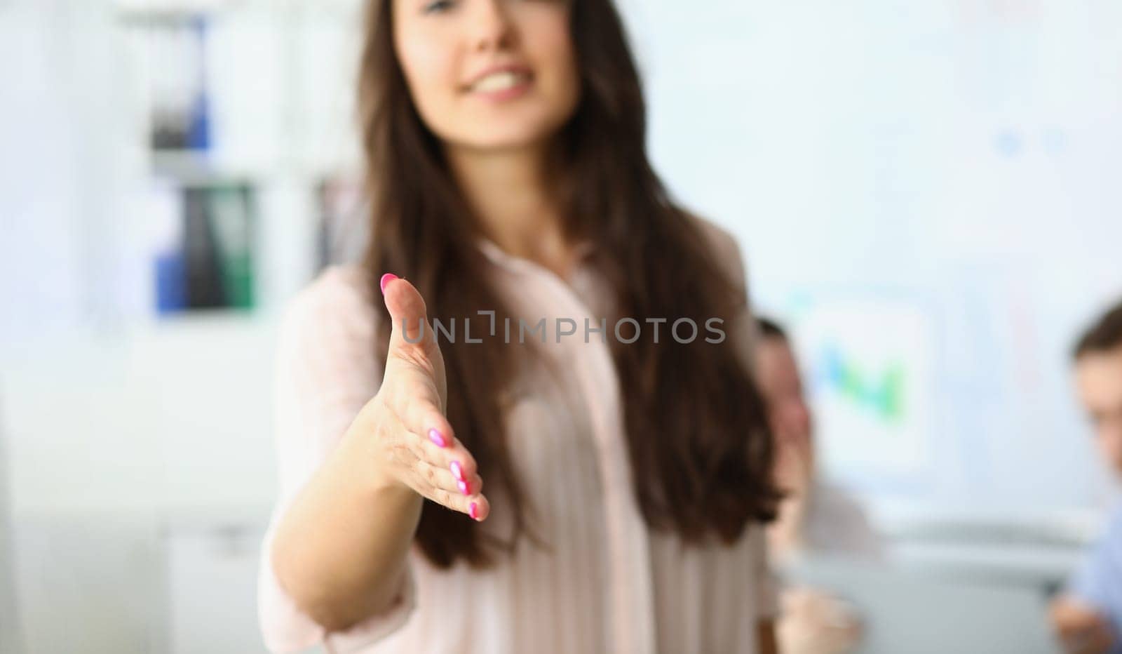 Closeup of business woman holding out hands for handshake and welcome gesture. Business meeting in office and handshake concept