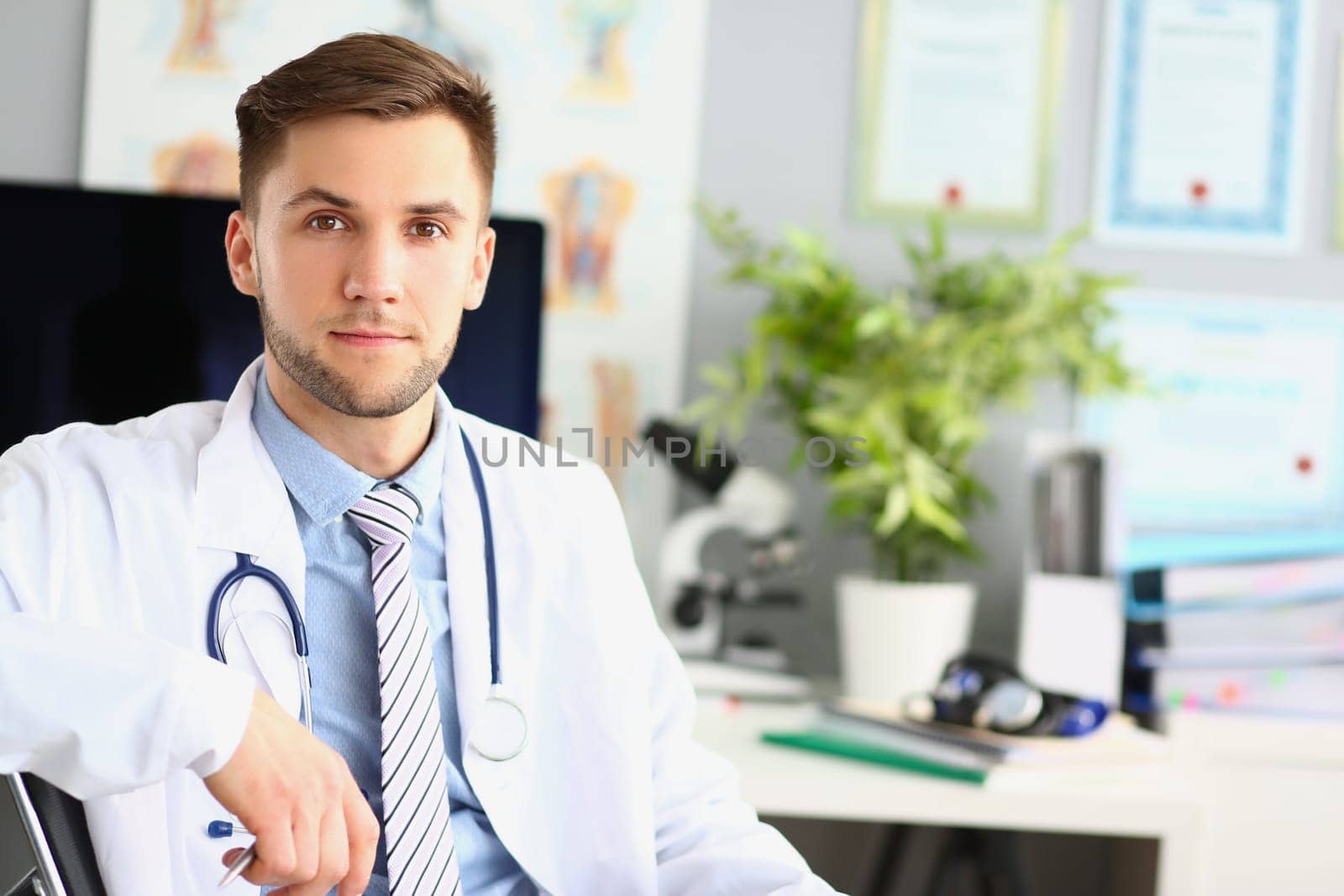 Portrait of young doctor therapist cardiologist in clinic. Medical care doctor appointment or insurance concept