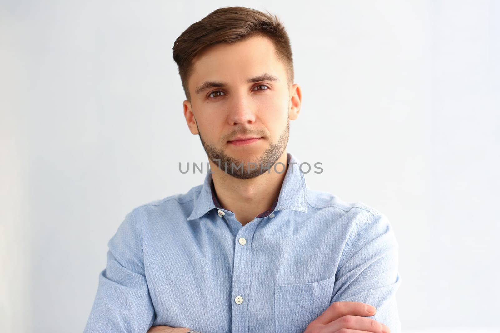 Portrait of handsome young business man posing for camera. Smart attractive guy employee consultant manager in blue shirt