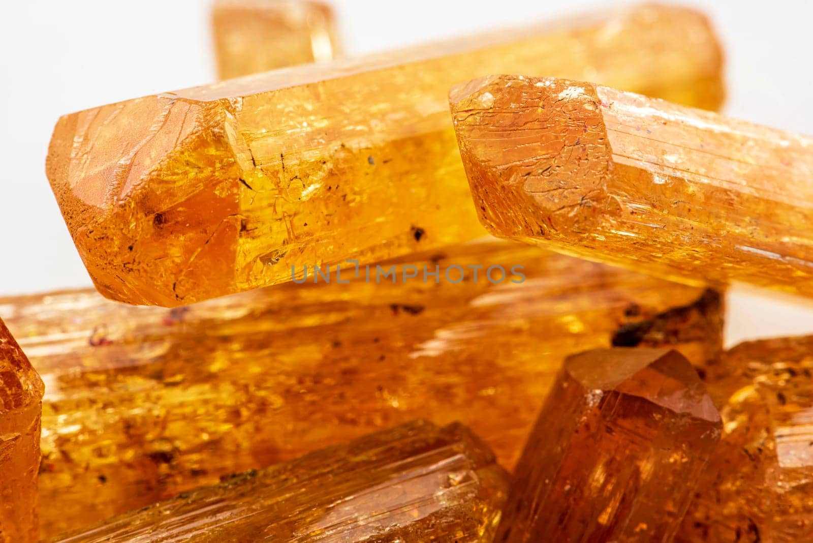 Studio photography of Brazilian imperial topaz in raw state with white background