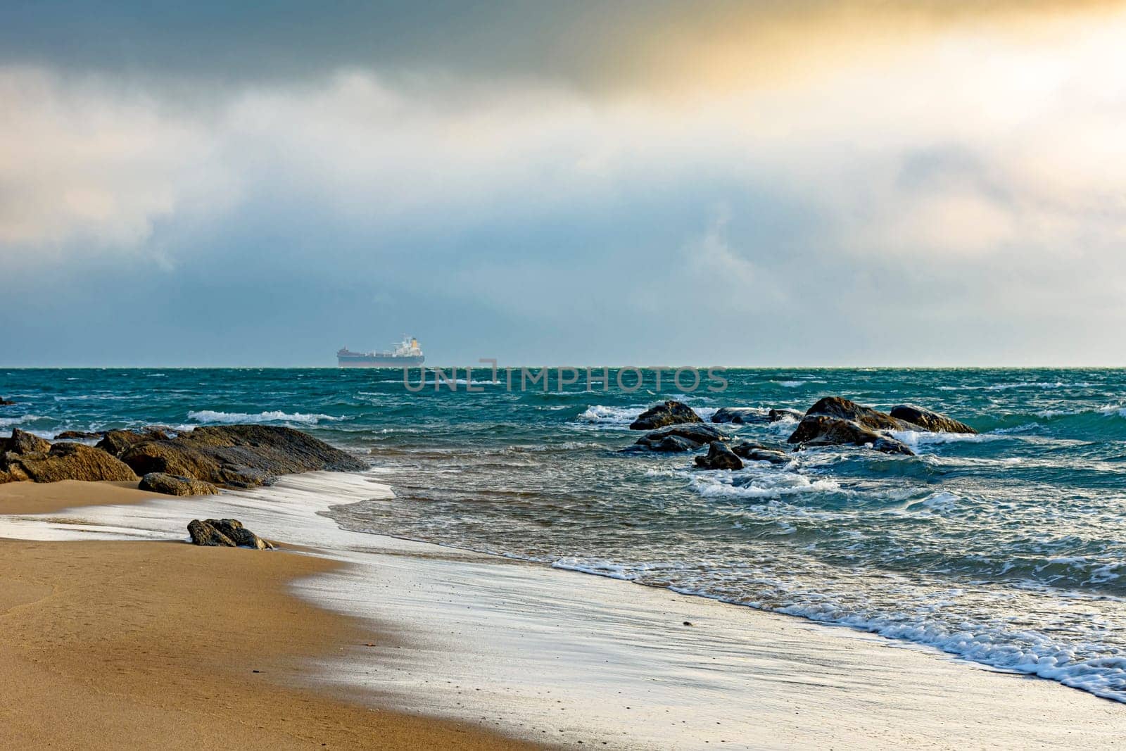 Ship moored during sunset on overcast day at Ilhabela island sea horizon