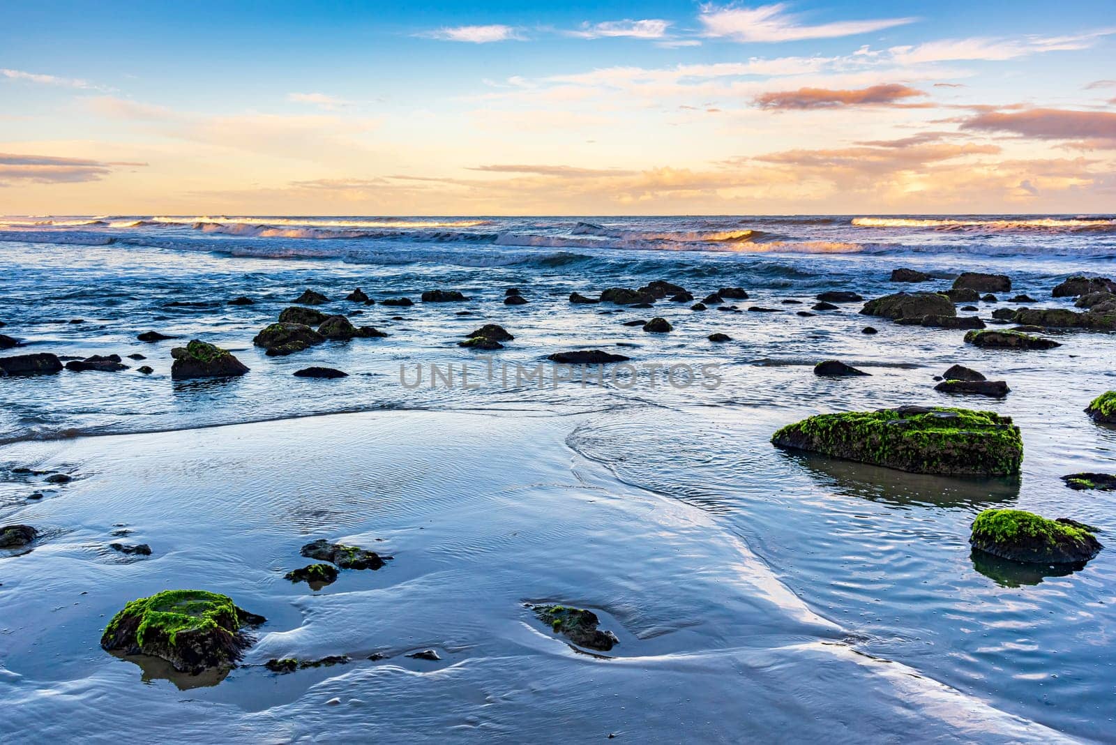 Quiet and deserted beach with rocks during sunset in the city of Torres in Rio Grande do Sul