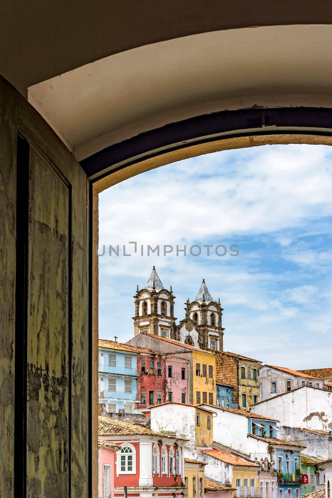 View of the famous Pelourinho neighborhood in the city of Salvador through an old colonial style wooden window