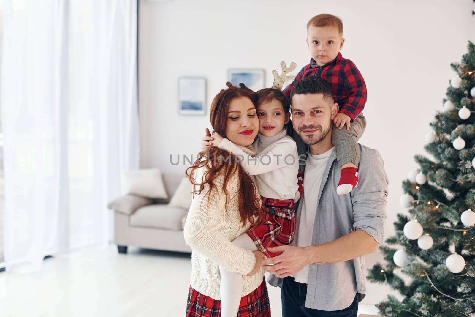 Beautiful family celebrates New year and christmas indoors at home by Standret