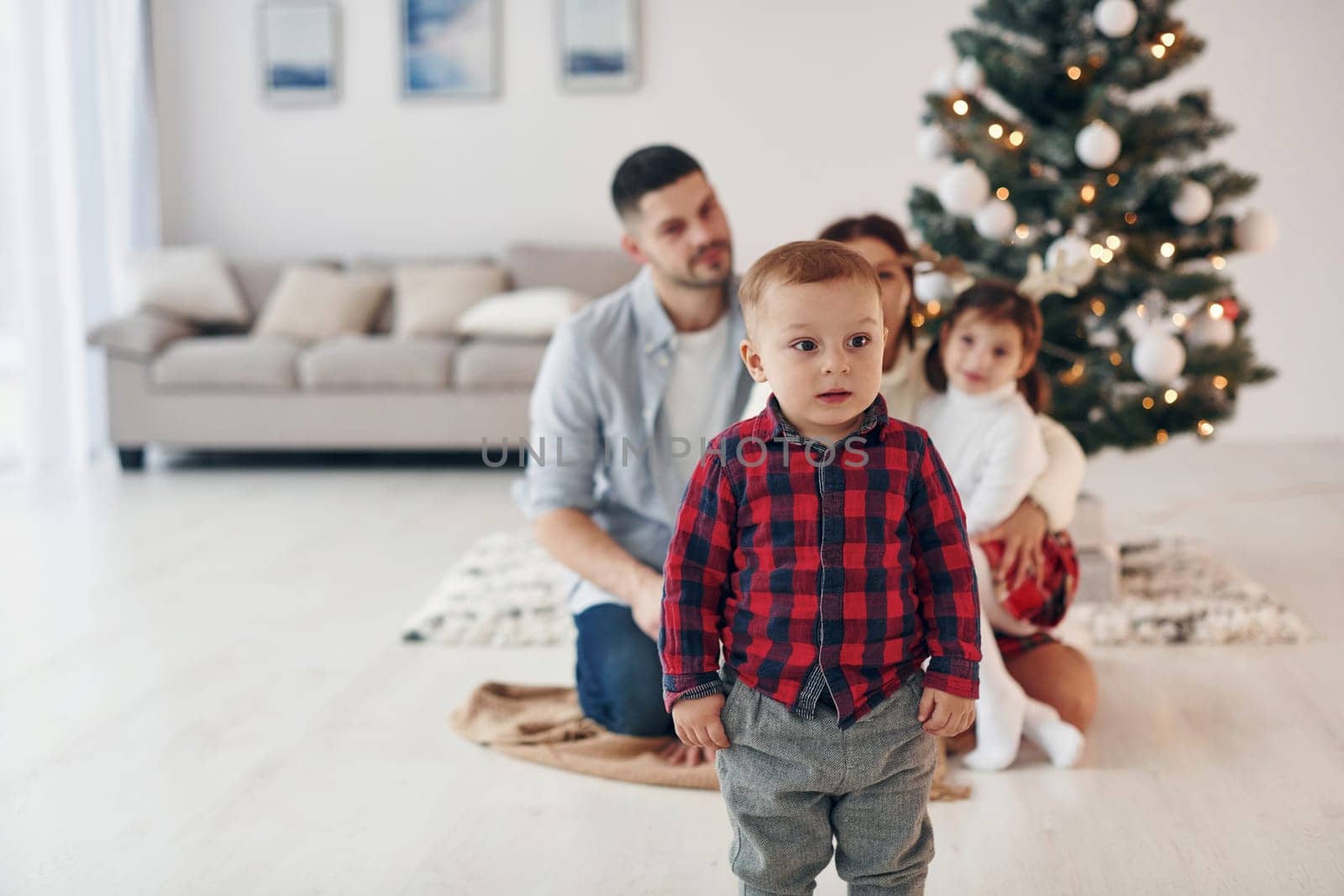 Beautiful family celebrates New year and christmas indoors at home by Standret