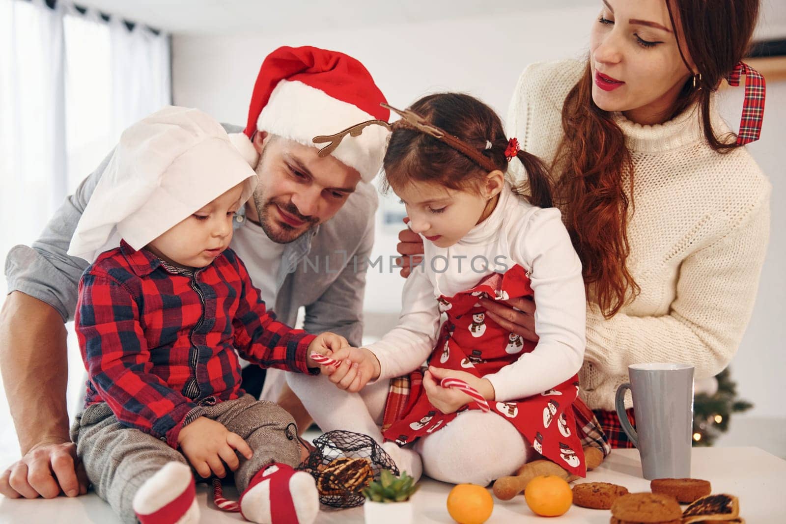 Sister and brother have fun. Beautiful family celebrates New year and christmas indoors at home by Standret