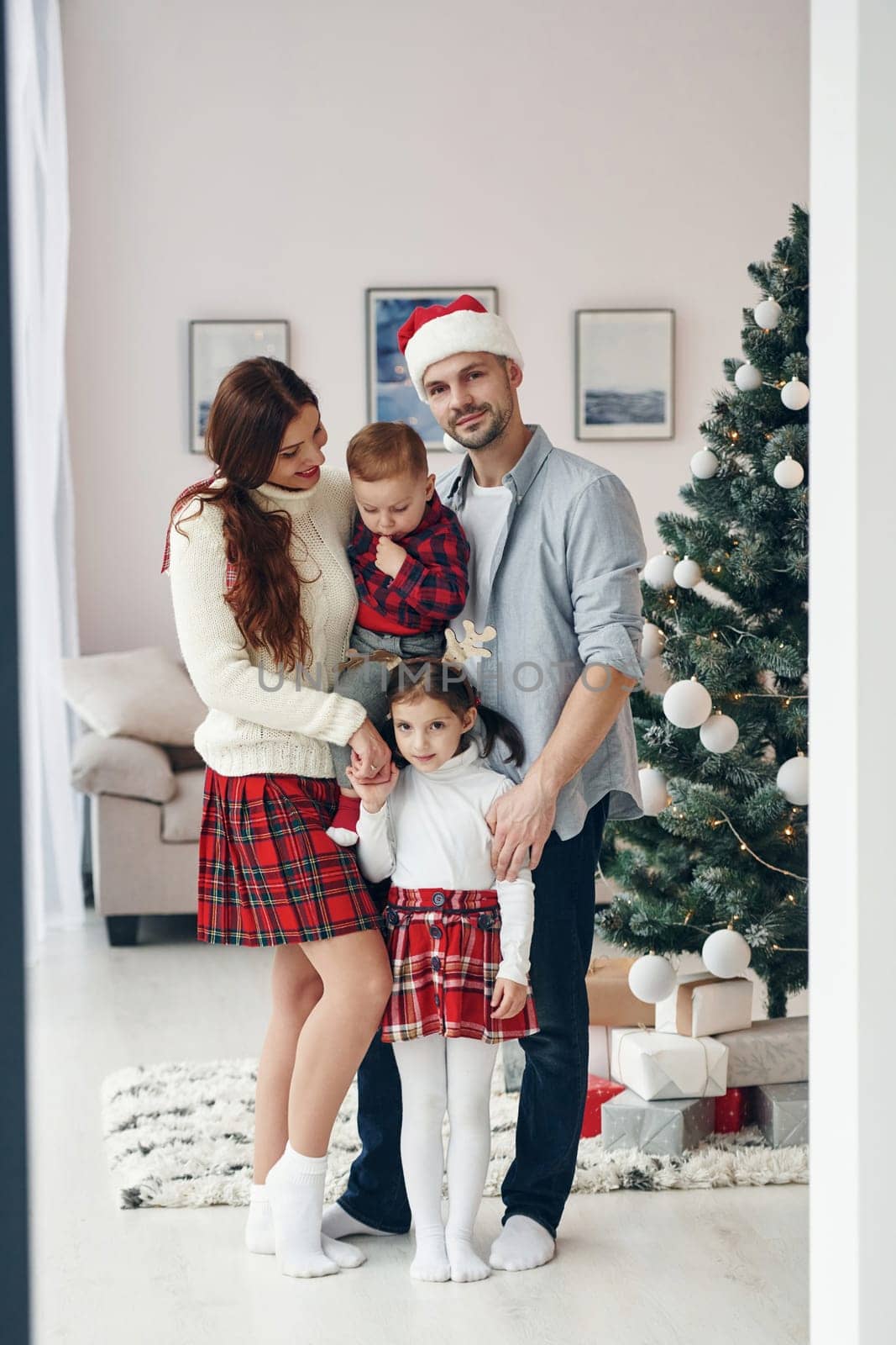 Standing together. Beautiful family celebrates New year and christmas indoors at home.