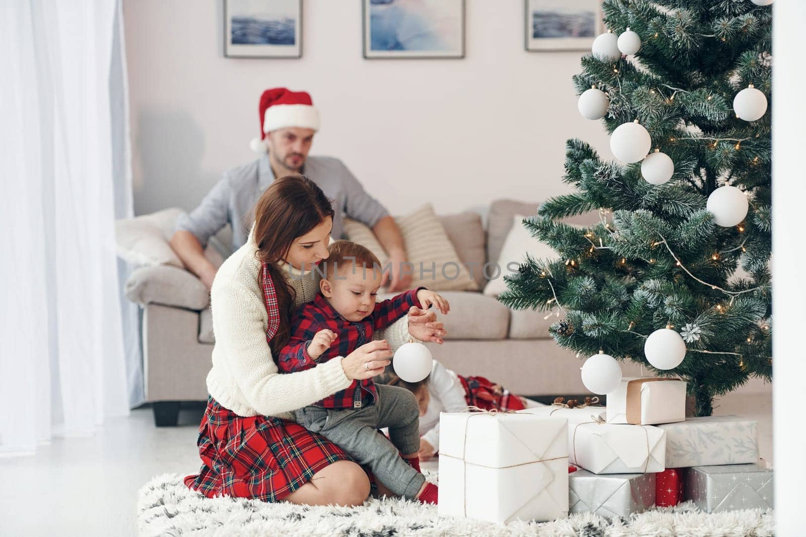 Beautiful family celebrates New year and christmas indoors at home by Standret