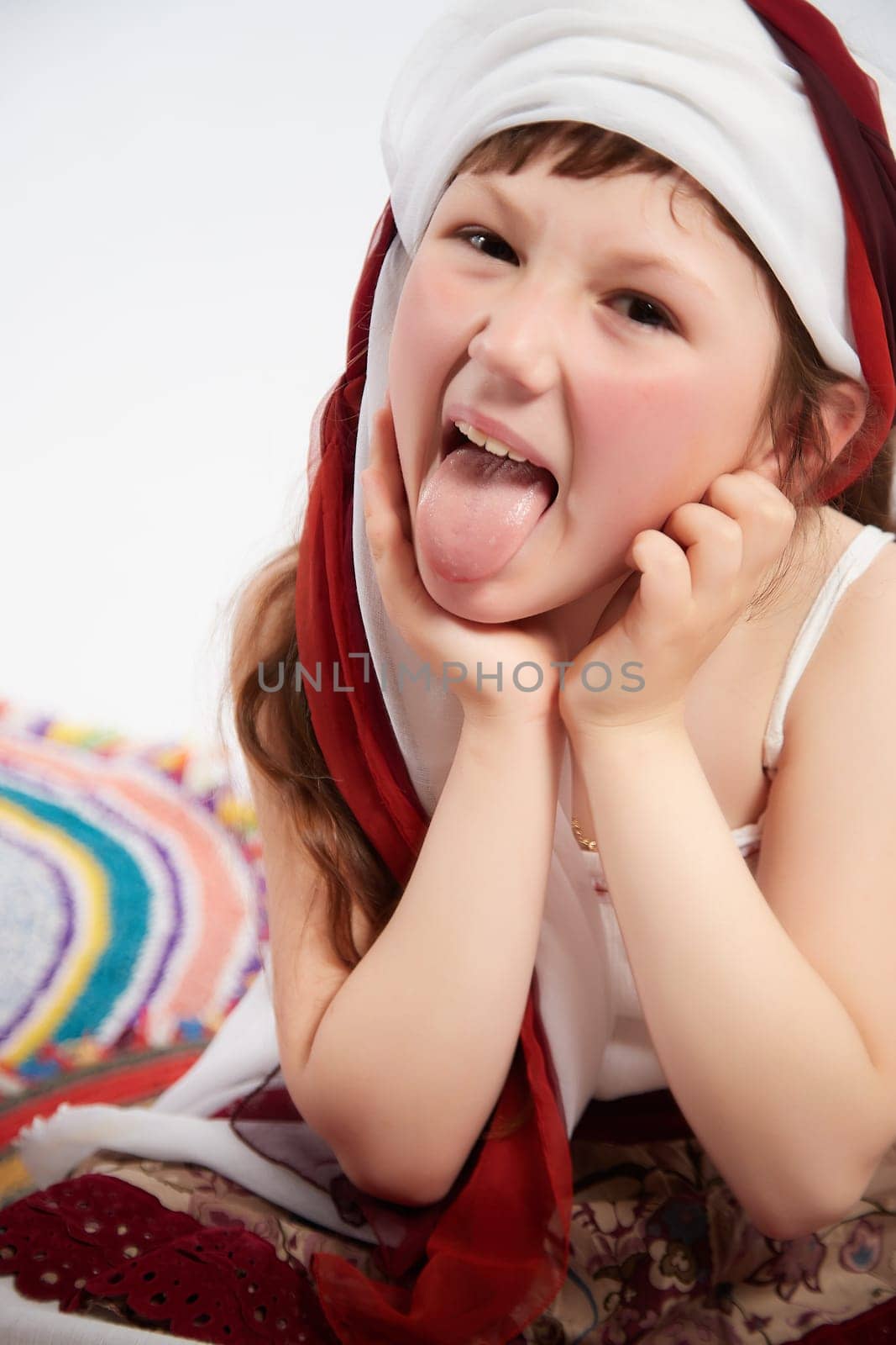 Portrait of Little girl in a stylized Tatar national costume on a white background in the studio. Photo shoot of funny young teenager who is not a professional model