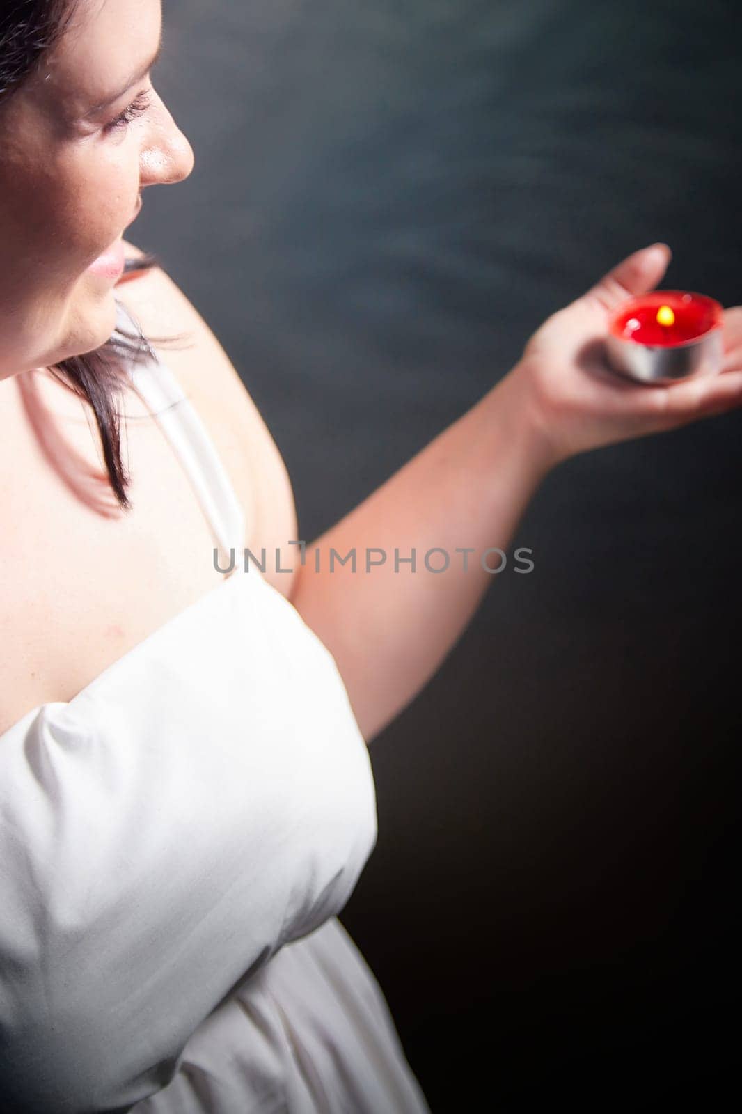 Slavic plump plump chubby girl in long white dress on the feast of Ivan Kupala with flowers and water in a river or lake on a summer evening by keleny