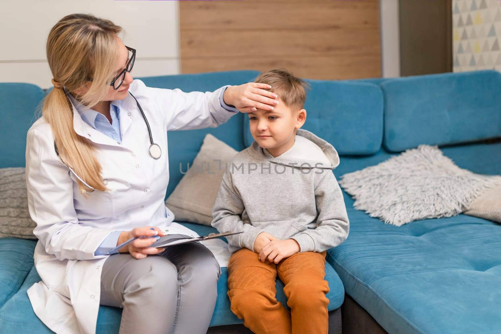 A family doctor examines a little boy at home. Pediatrician girl treats a child.