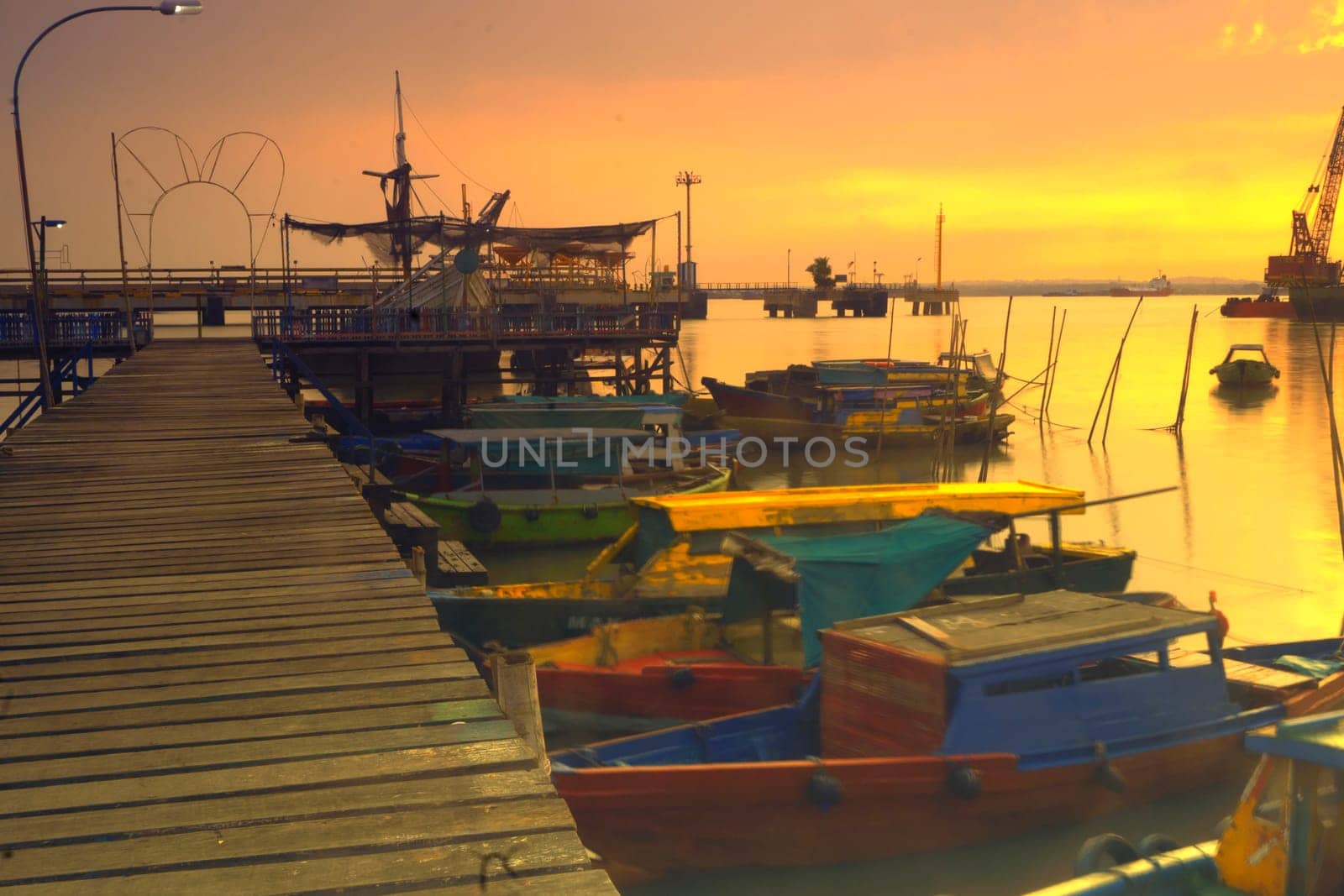 View of wooden pier on boat dock wharf in Gresik, East Java, Indonesia during sunrise