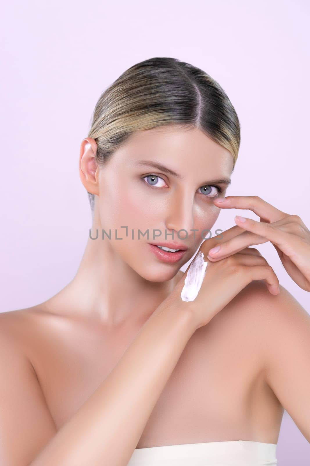 Alluring beautiful woman applying moisturizer cream on her hand for perfect skin by biancoblue