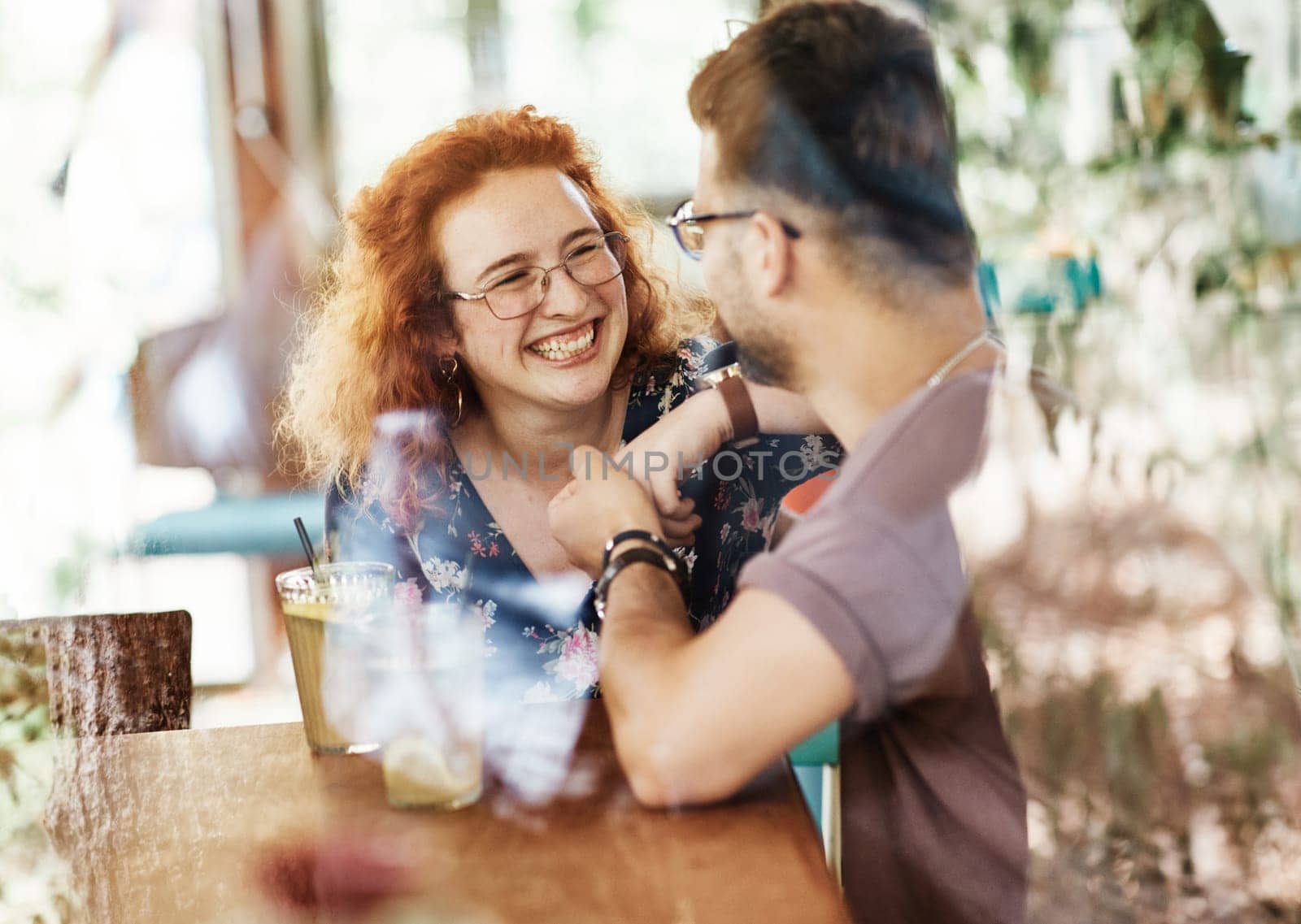 Happy young couple smiling and talking in a coffee shop cafe