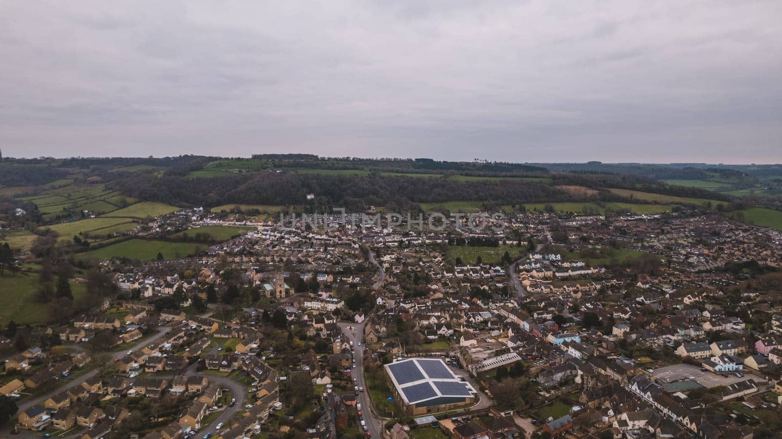 Aerial view of neighborhood surrounded by green landscape. High quality photo