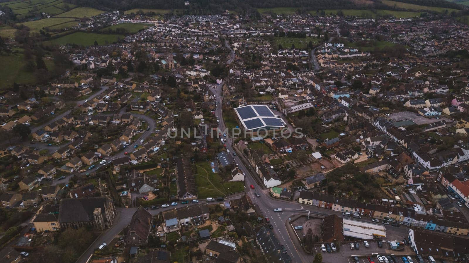Aerial view of neighborhood surrounded by green landscape. High quality photo