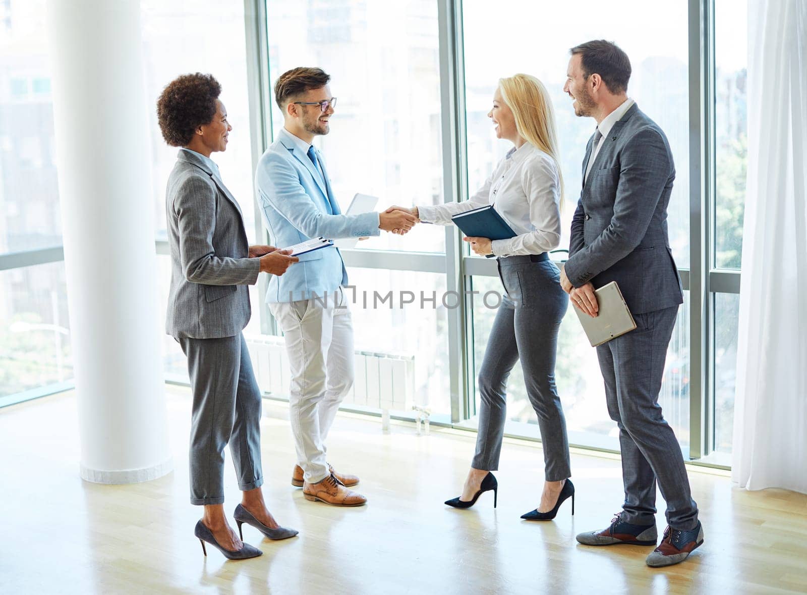 portrait of a young beautiful businesspeople shaking hands introducing each other in a new office