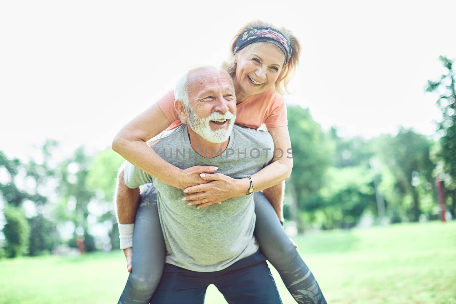 outdoor senior fitness woman man lifestyle active sport exercise healthy fit retirement love fun piggyback by Picsfive