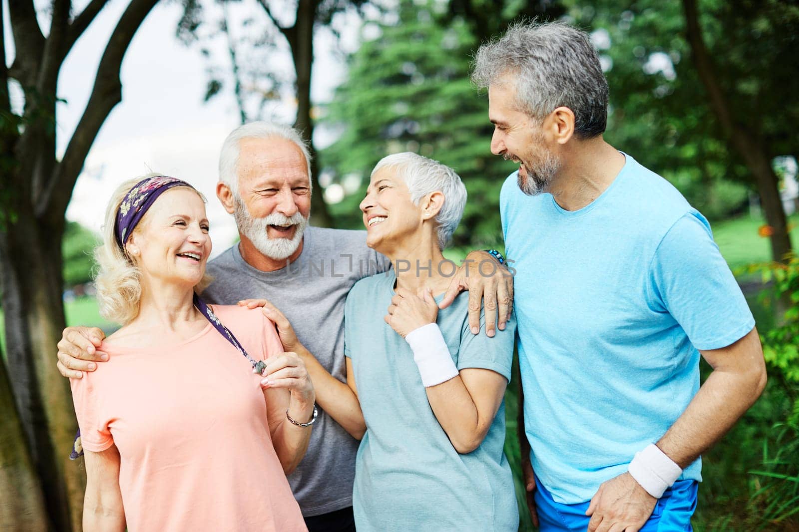 Smiling active senior people posing together in the park