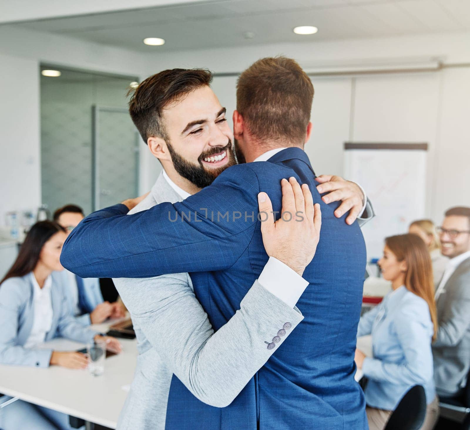 Coworkers hugging and celebrating in the office, or a happy young couple love