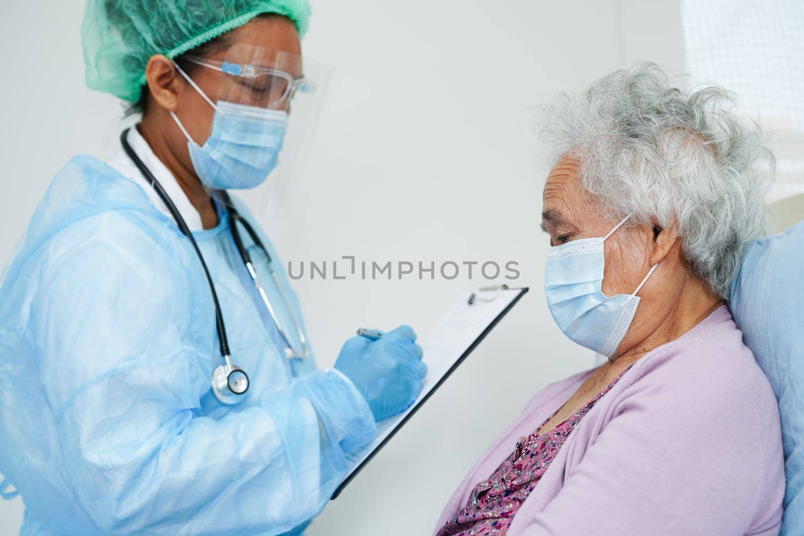 Doctor check Asian elder senior woman patient wearing a mask for protect covid coronavirus.