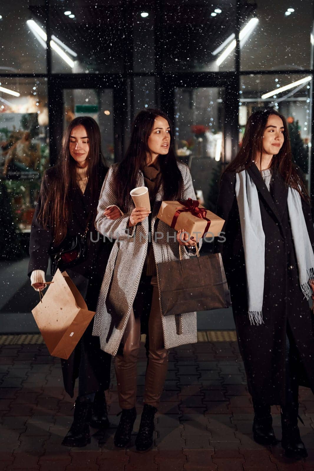 After shopping. Three cheerful women spends Christmas holidays together outdoors. Conception of new year.