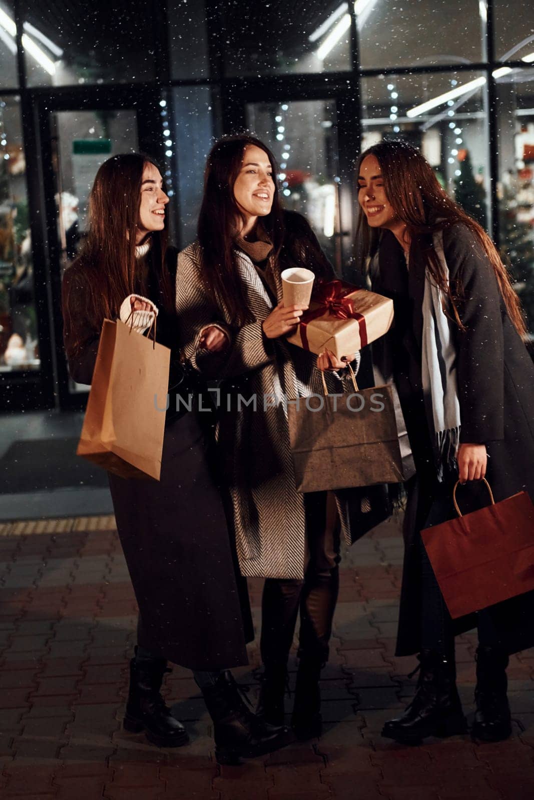 After shopping. Three cheerful women spends Christmas holidays together outdoors. Conception of new year.