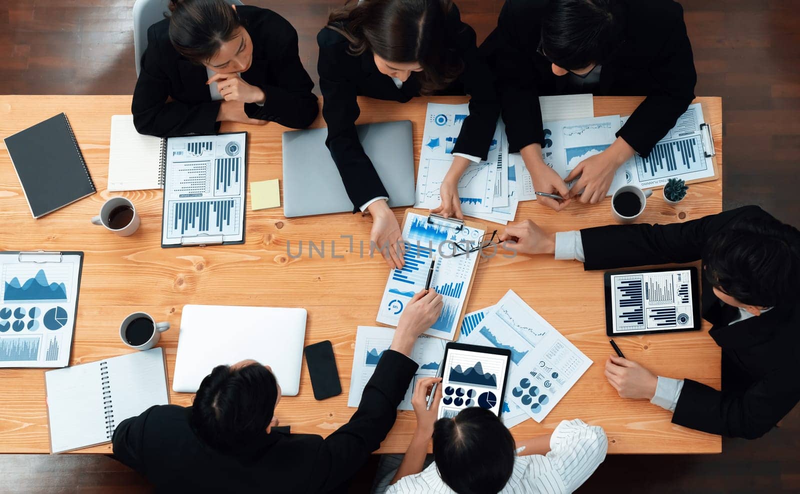 Top-view business team of financial data analysis meeting with business intelligence, report paper and dashboard on laptop for marketing strategy. Business people working together in office of harmony