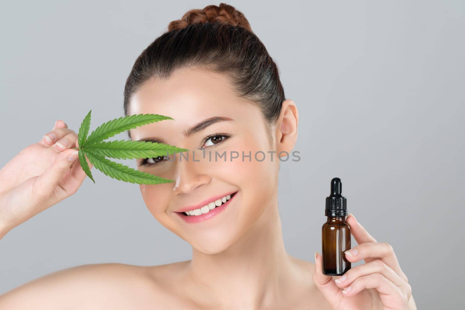 Glamorous beautiful woman holding cannabis oil and green leaf. by biancoblue