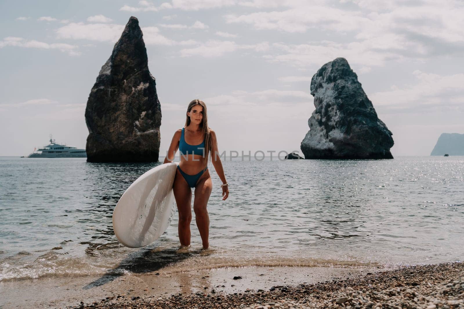 Woman sea sup. Close up portrait of happy young caucasian woman with long hair looking at camera and smiling. Cute woman portrait in bikini posing on sup board in the sea by panophotograph