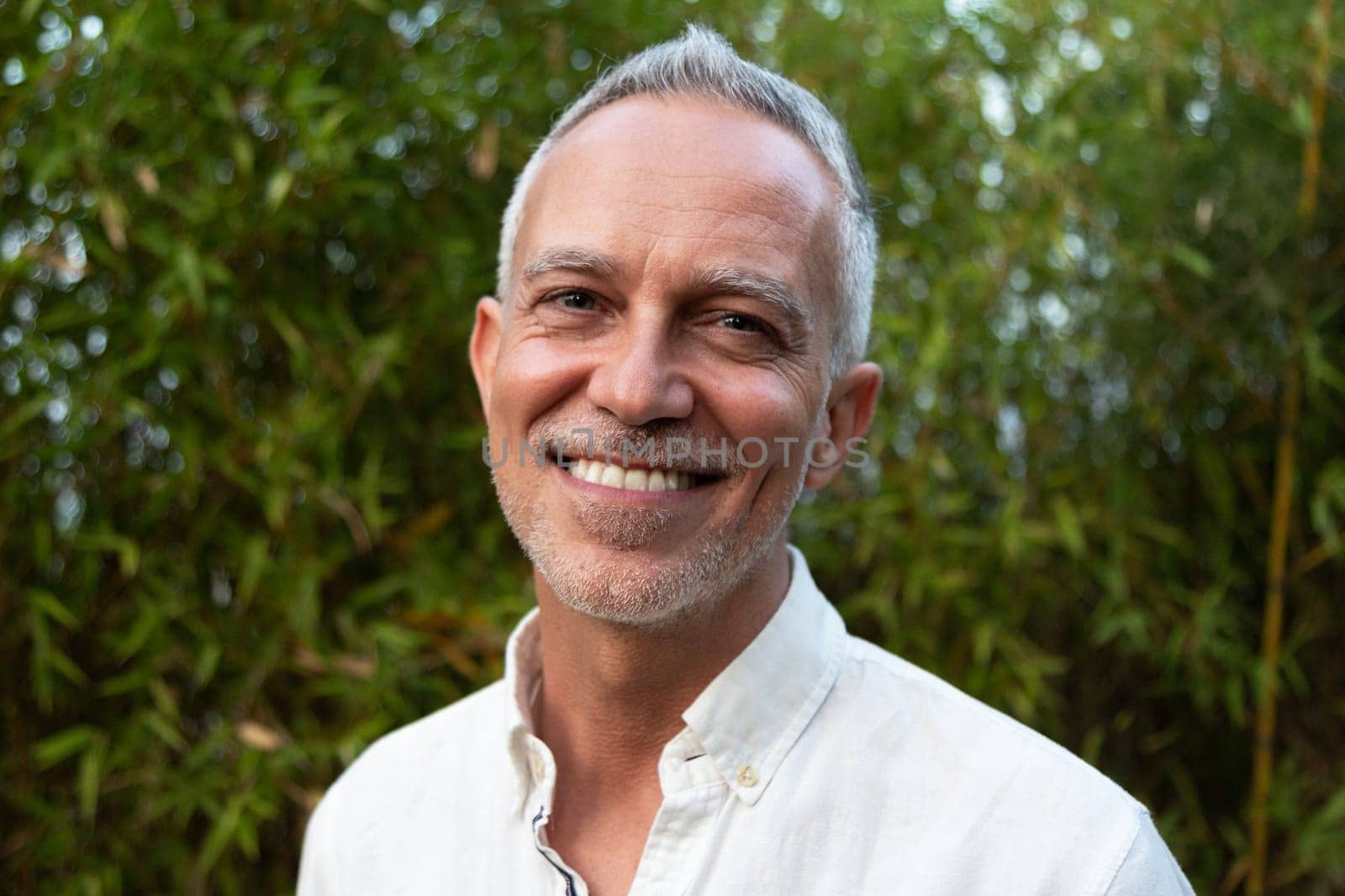 Horizontal headshot of smiling white man in nature. Lifestyle.