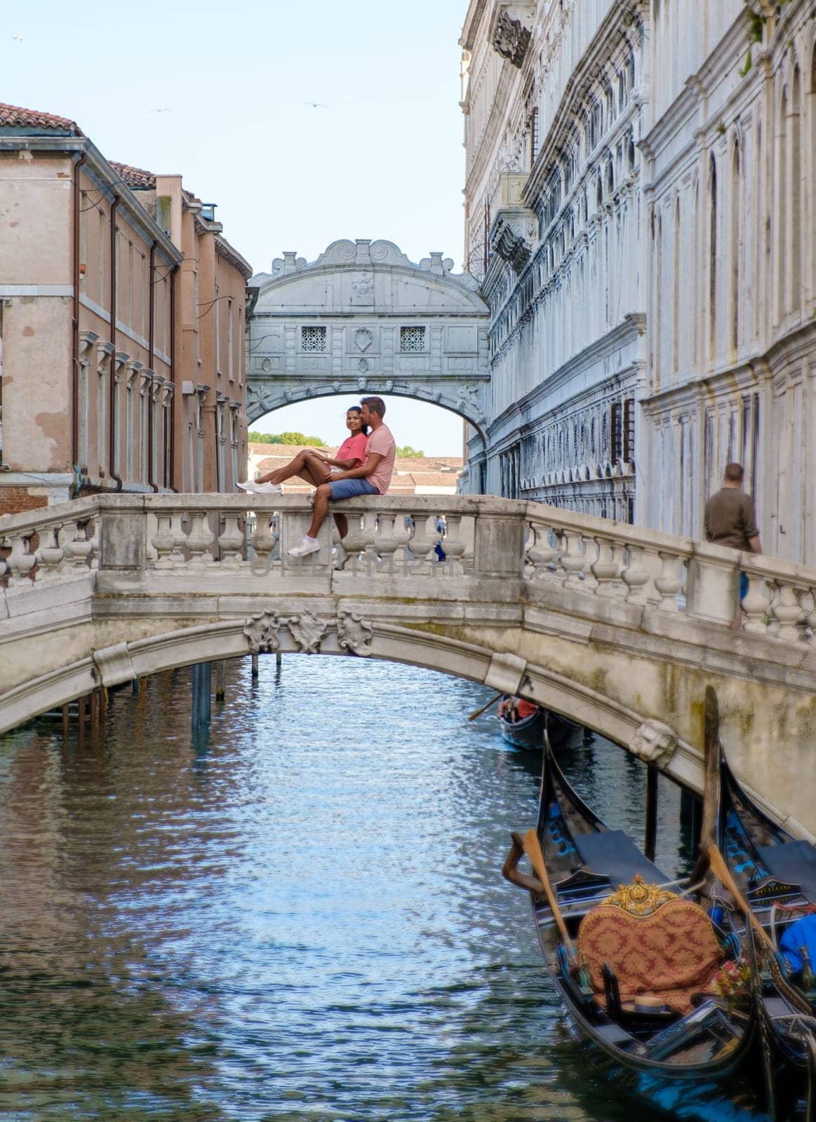 a couple of men and women on a city trip in Venice Italy sitting at a bridge in Venice, Italy. Architecture and landmark of Venice. cityscape of Venice Italy during summer
