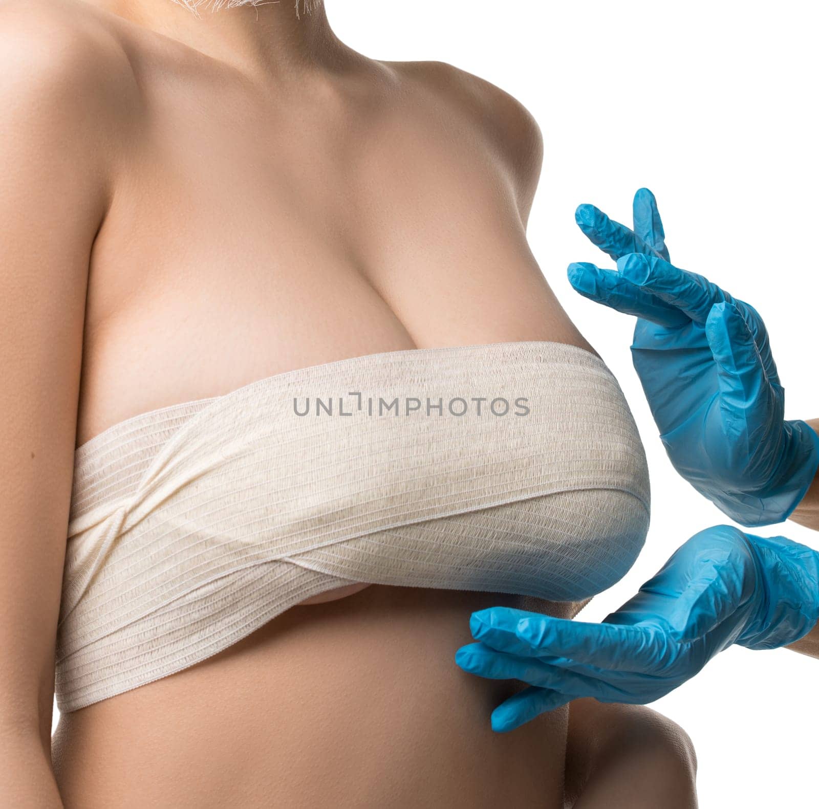Beautiful woman with bandaged face and breasts examined by a plastic surgeon isolated shot on white background