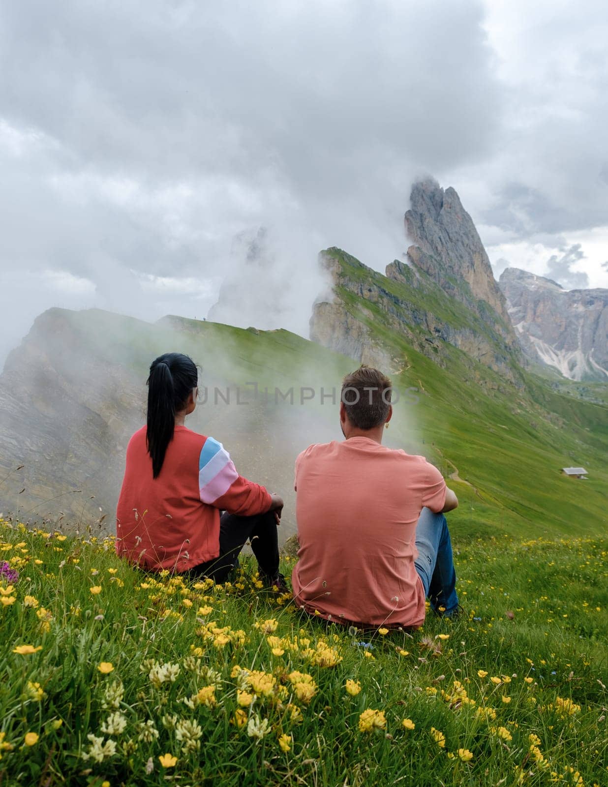 couple on vacation hiking in the Italian Dolomites, Amazing view on Seceda peak. Trentino Alto Adige, Dolomites Alps, South Tyrol, Italy, Europe. Odle mountain range, Val Gardena. Majestic Furchetta