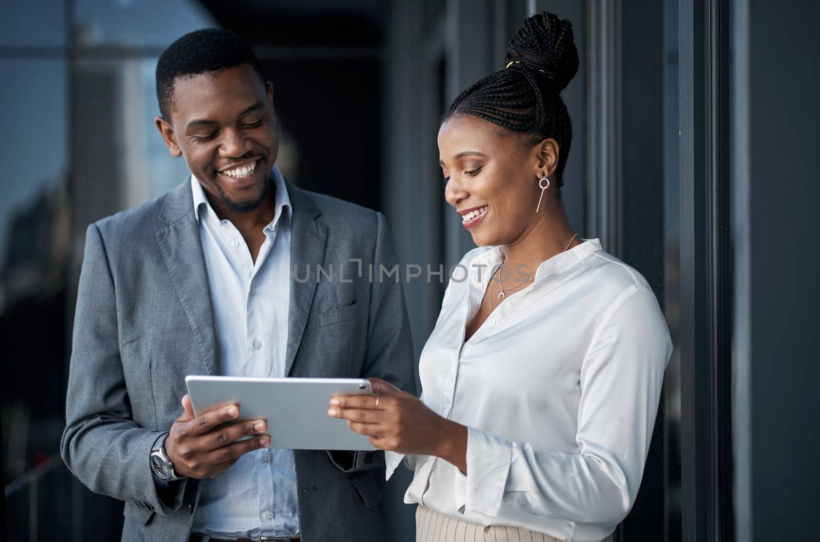 Communication is important for this business. two businesspeople standing outside together and having a discussion while using a digital tablet. by YuriArcurs